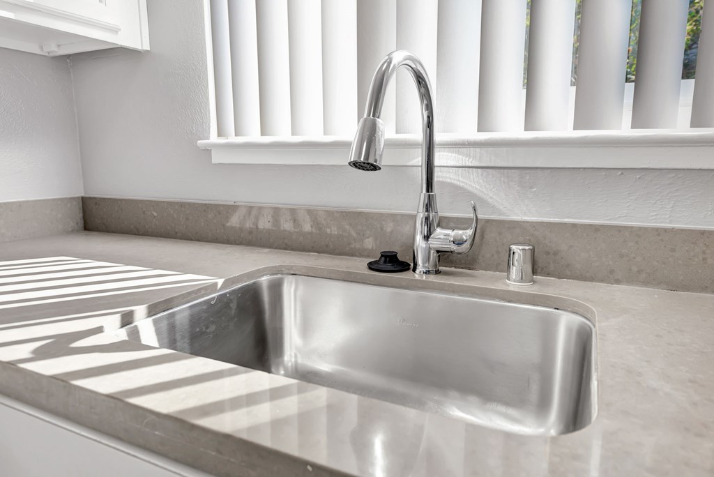 A modern kitchen sink with a chrome faucet.