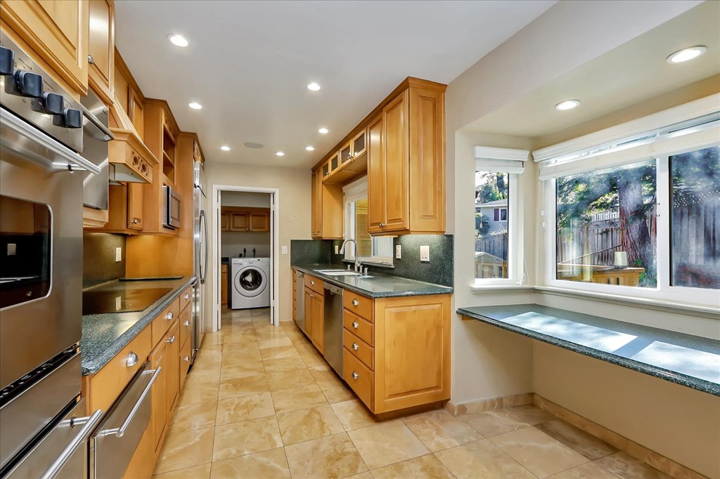 a large kitchen with wooden cabinets and stainless steel appliances