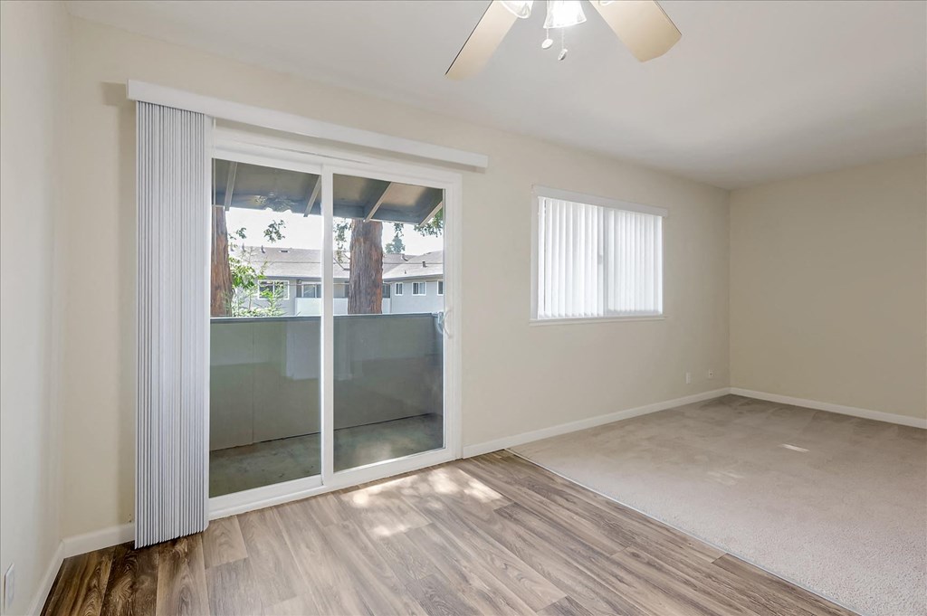 an empty living room with sliding glass doors to a patio