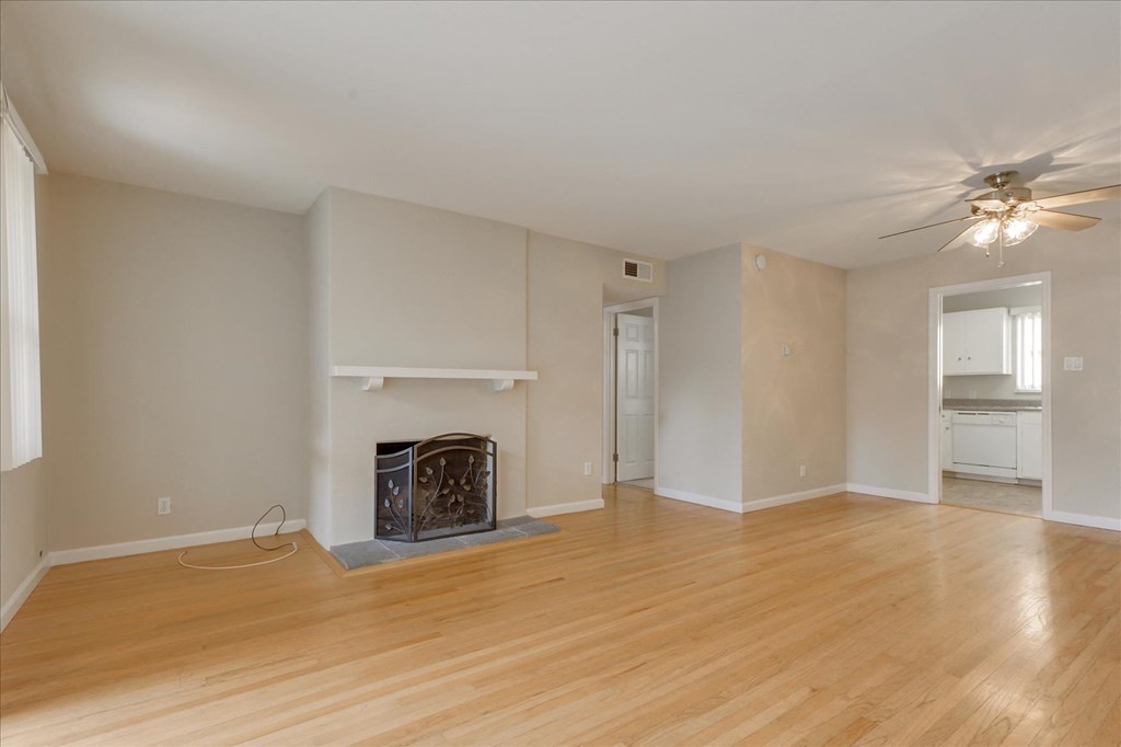 a living room with a fireplace and a ceiling fan