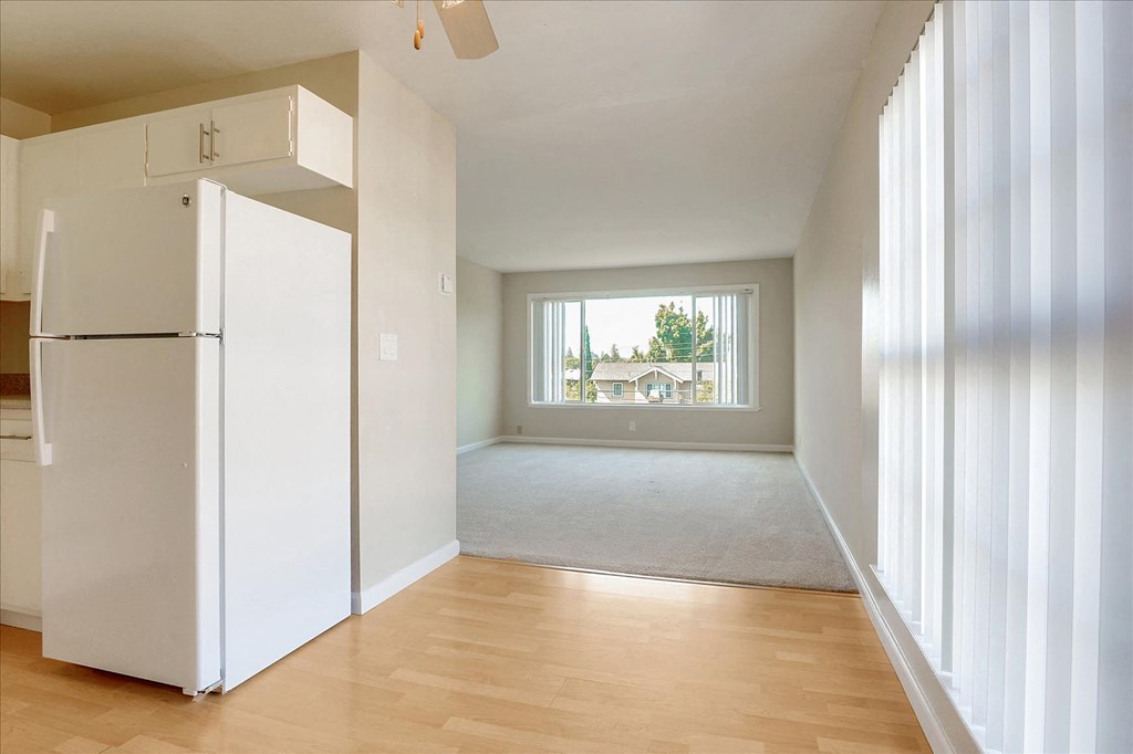 a renovated living room with a window and a white refrigerator