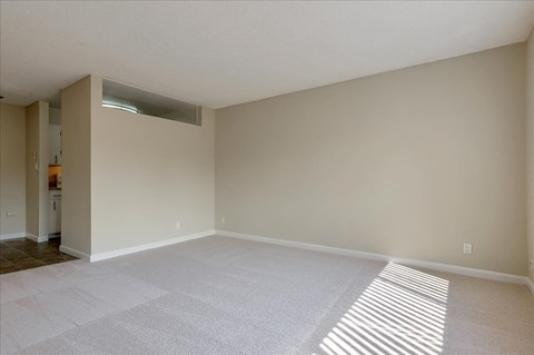 the living room and dining room of an empty house