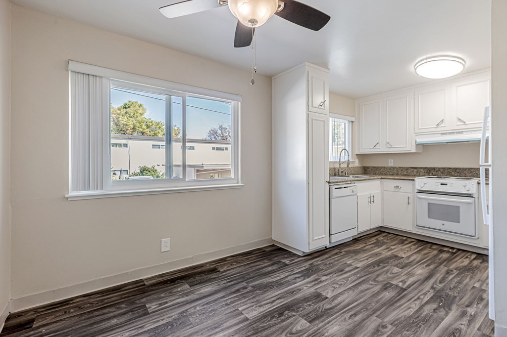 A kitchen with white cabinets and a ceiling fan.