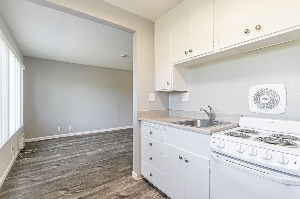 A kitchen with white appliances and cabinets.