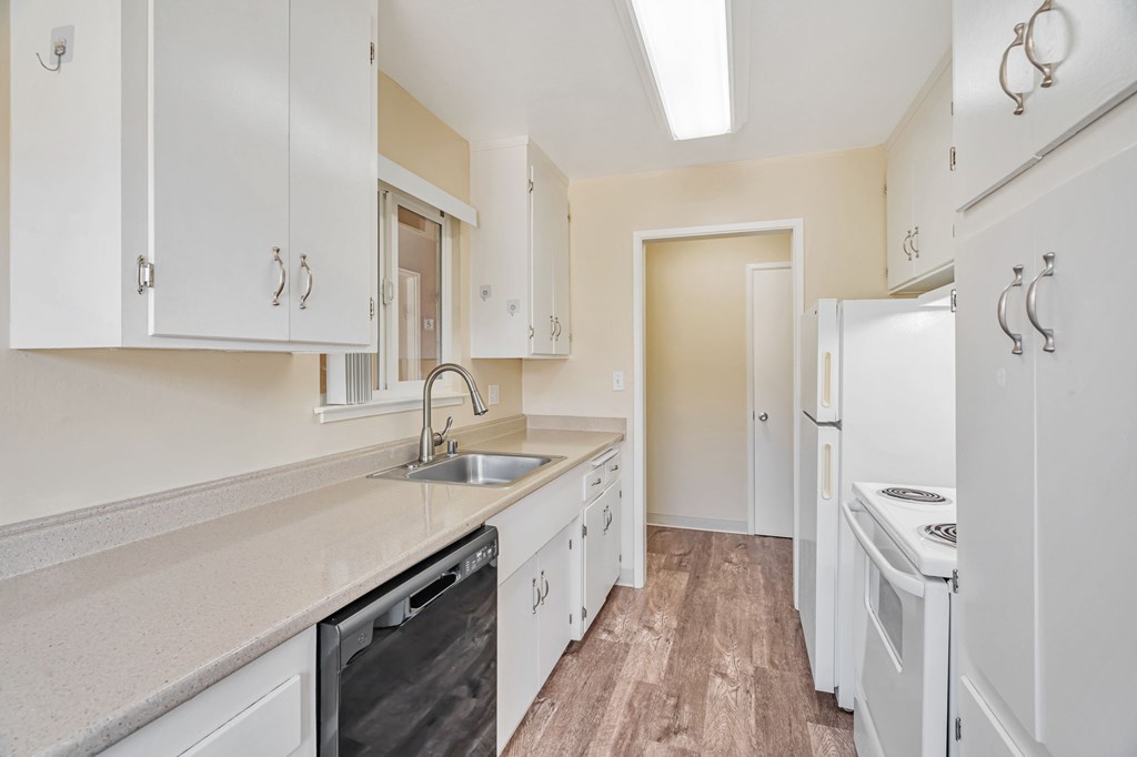 A kitchen with white cabinets and appliances.