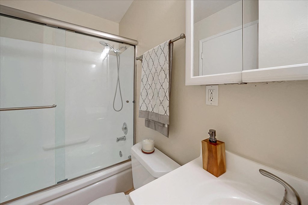 a bathroom with a shower and a sink and a toilet