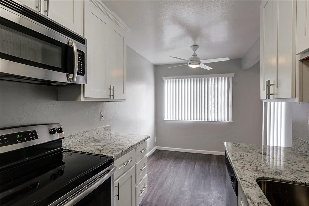 A kitchen with a black stove top oven and a black microwave above it.