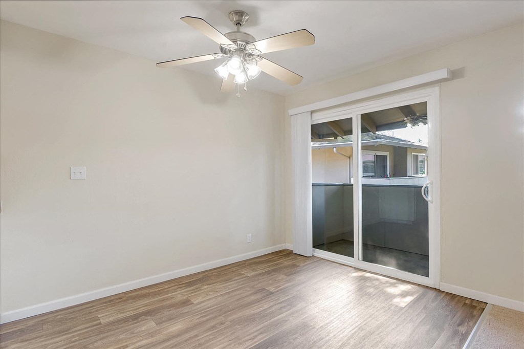 a living room with a sliding glass door and a ceiling fan