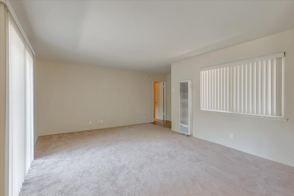 Empty room with carpeted floor and white walls.