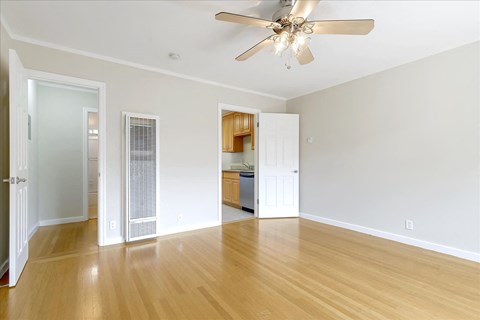 a living room with wood floors and a ceiling fan