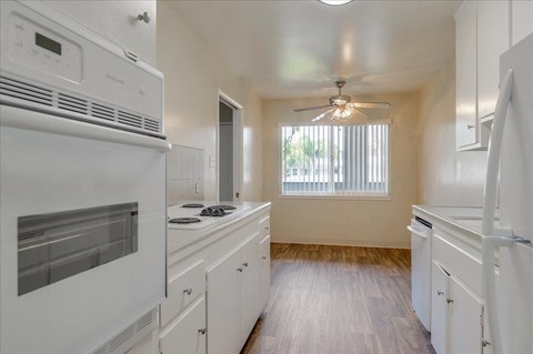 a kitchen with a stove and a ceiling fan