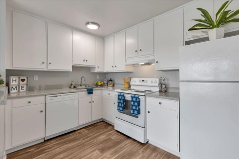 a kitchen with white cabinets and a white stove and refrigerator