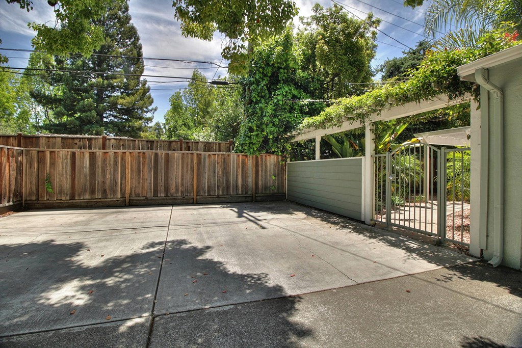 a large yard with a fence and a driveway