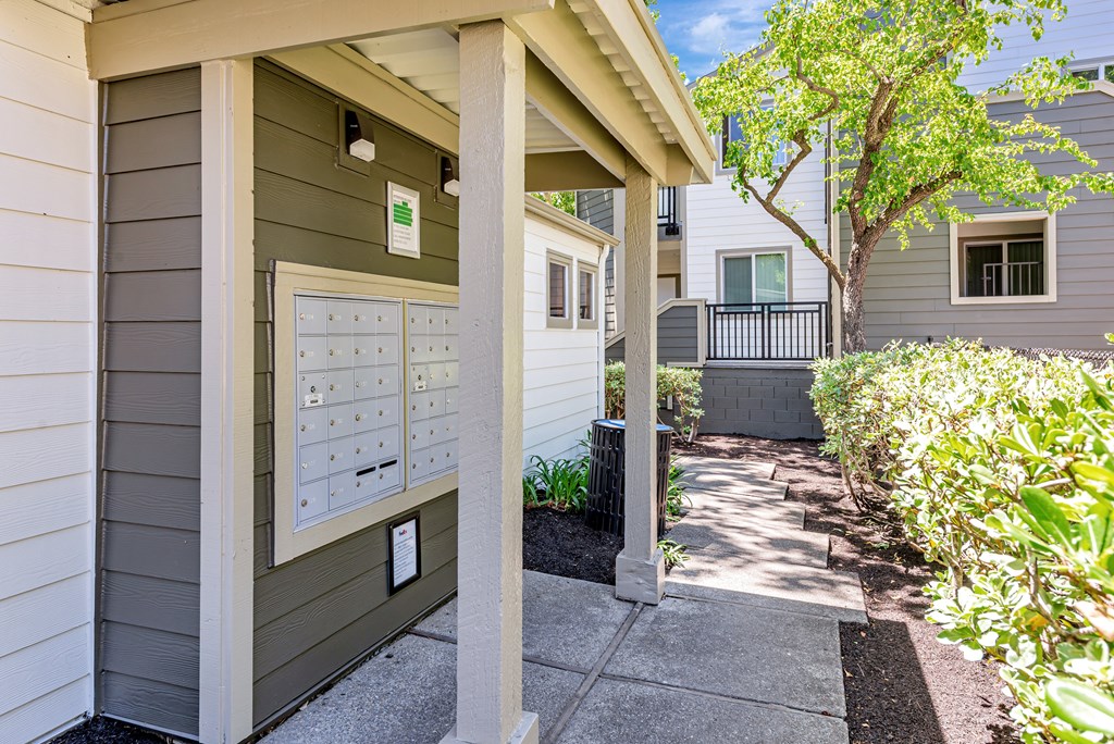 A grey house with a mailbox on the front porch.