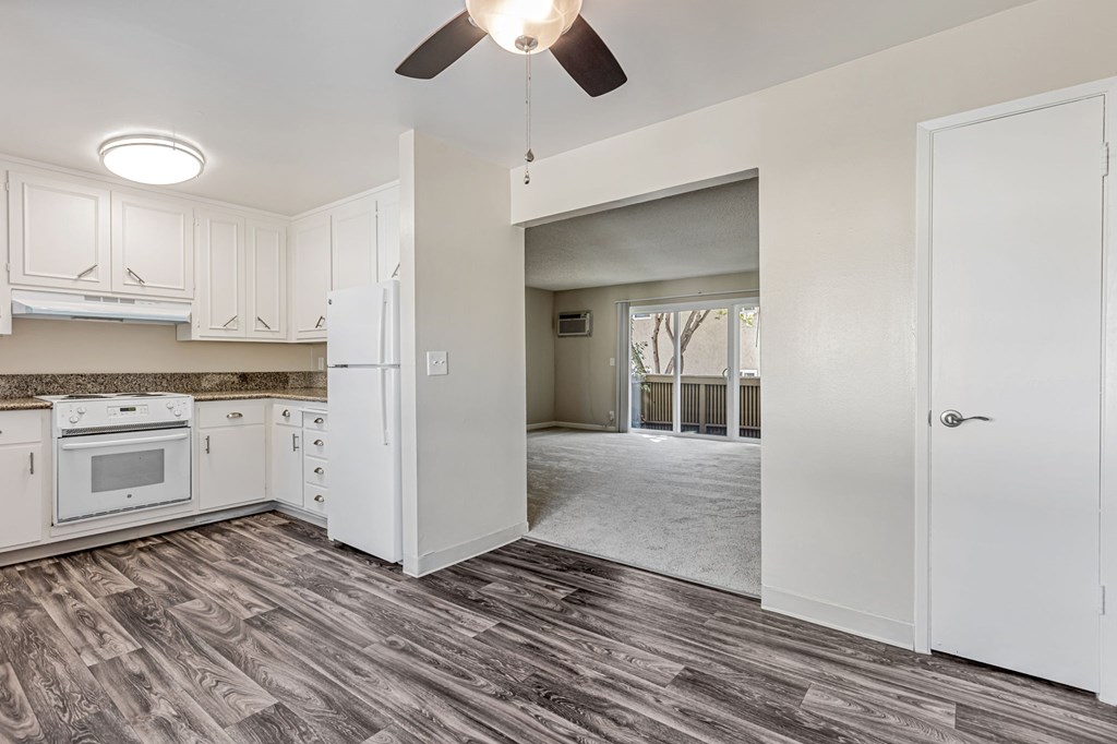 A kitchen with white cabinets and a ceiling fan.