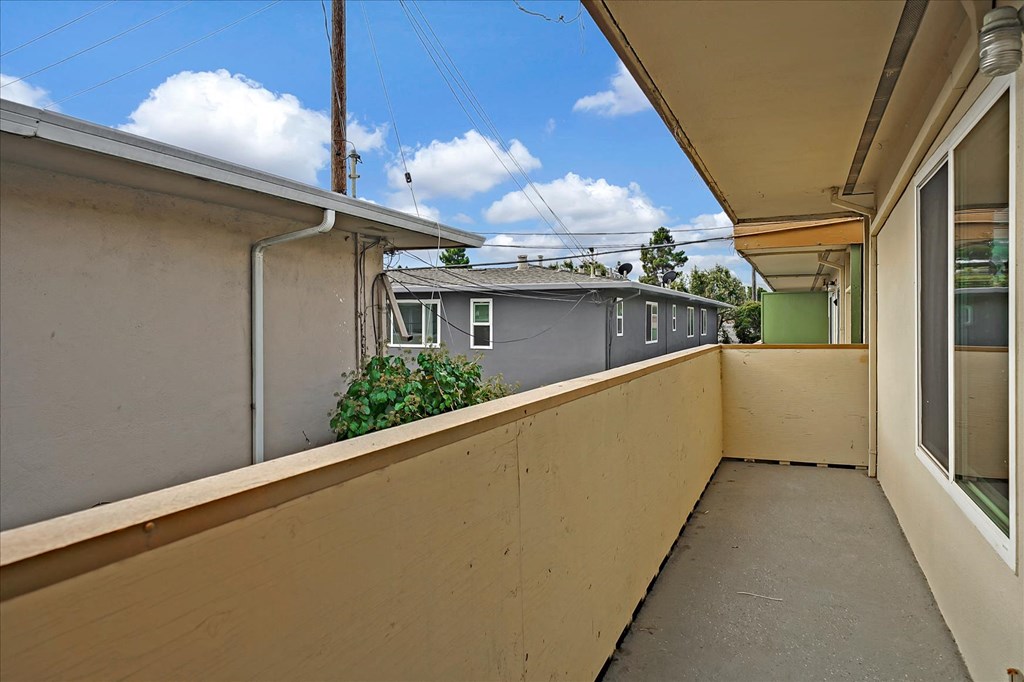 a long balcony with a view of a house