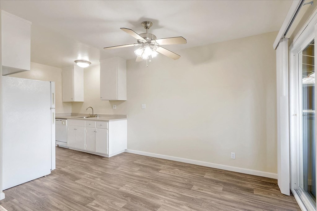 a room with a kitchen and a ceiling fan