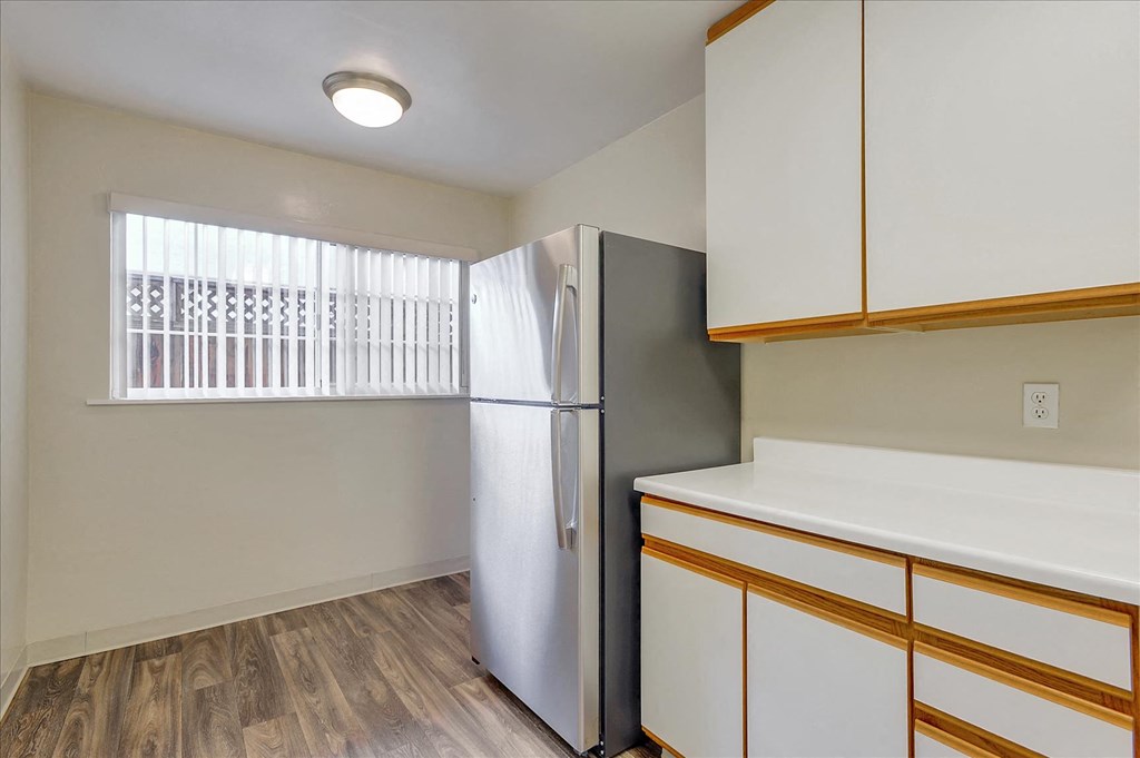 a kitchen with white cabinets and a refrigerator