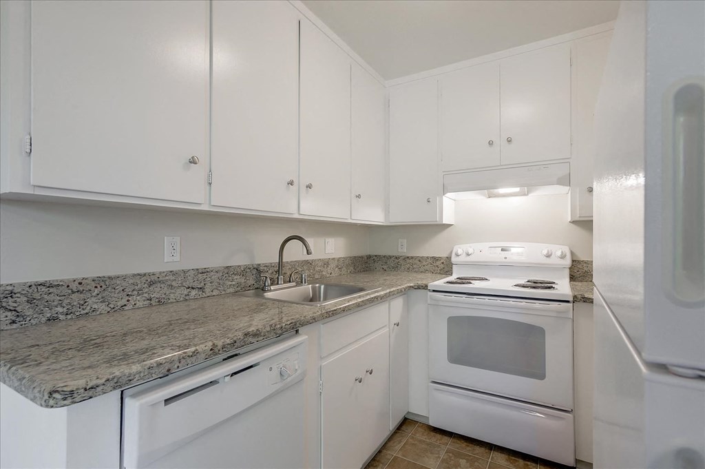a kitchen with white appliances and granite counter tops