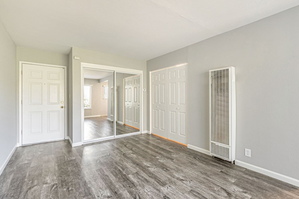 A room with a white door and a white wall with a window.