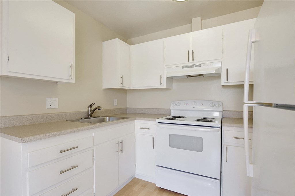 a white kitchen with white appliances and white cabinets