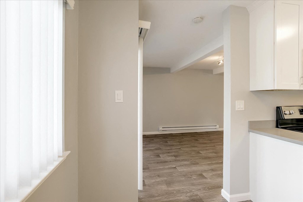 A kitchen area with a stove top oven and white cabinets.
