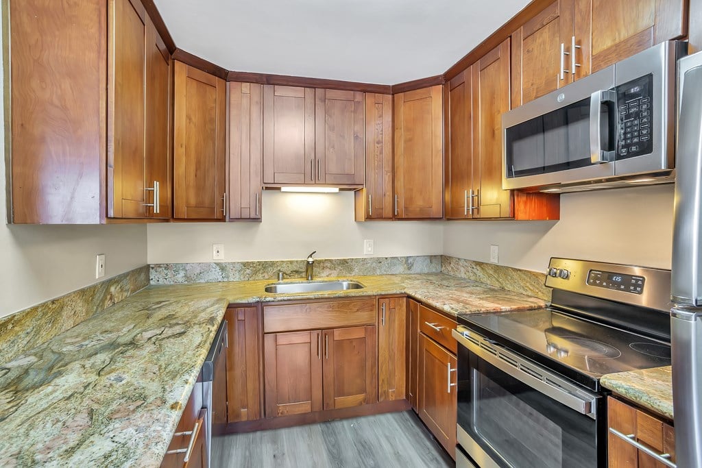 A kitchen with wooden cabinets and granite countertops.