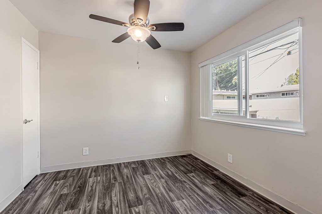 A room with a ceiling fan and a window.