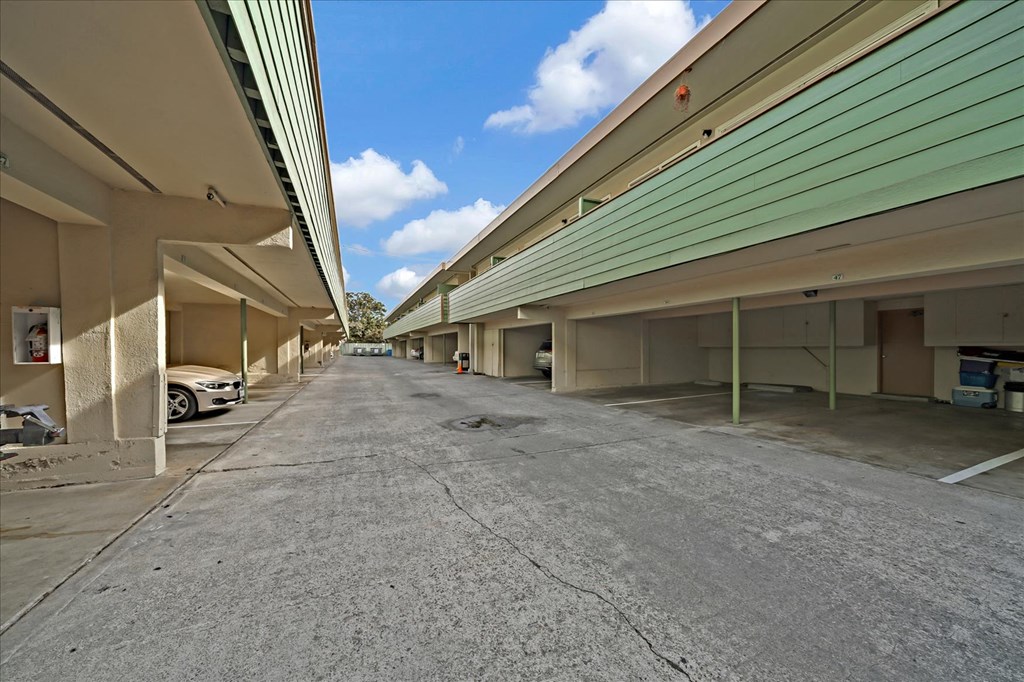 A parking lot with a car parked on the left side.