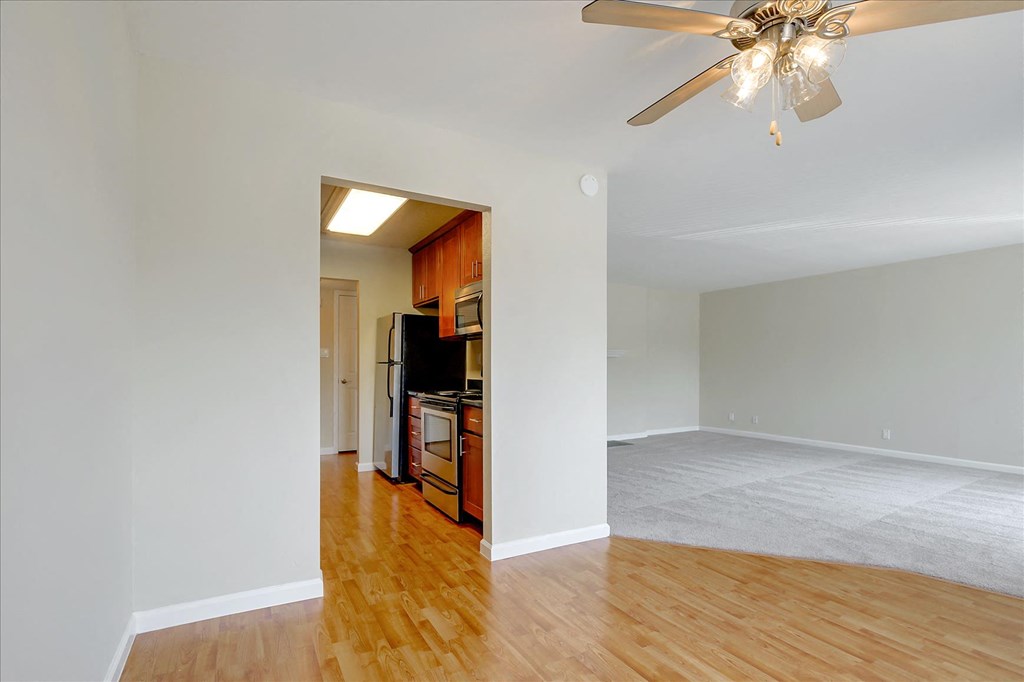 a living room and a kitchen with a ceiling fan