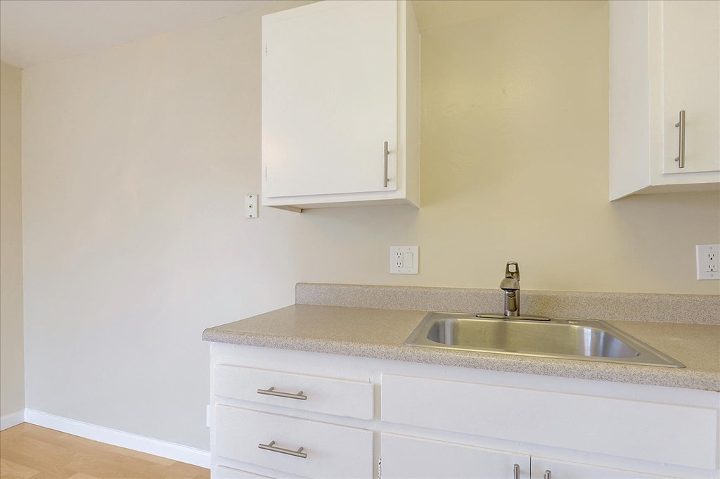 a kitchen with white cabinets and a sink