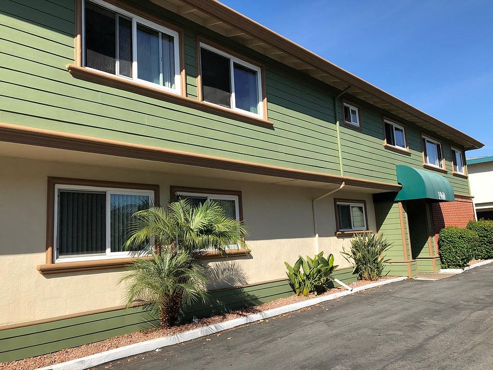 a green house with palm trees in front of it