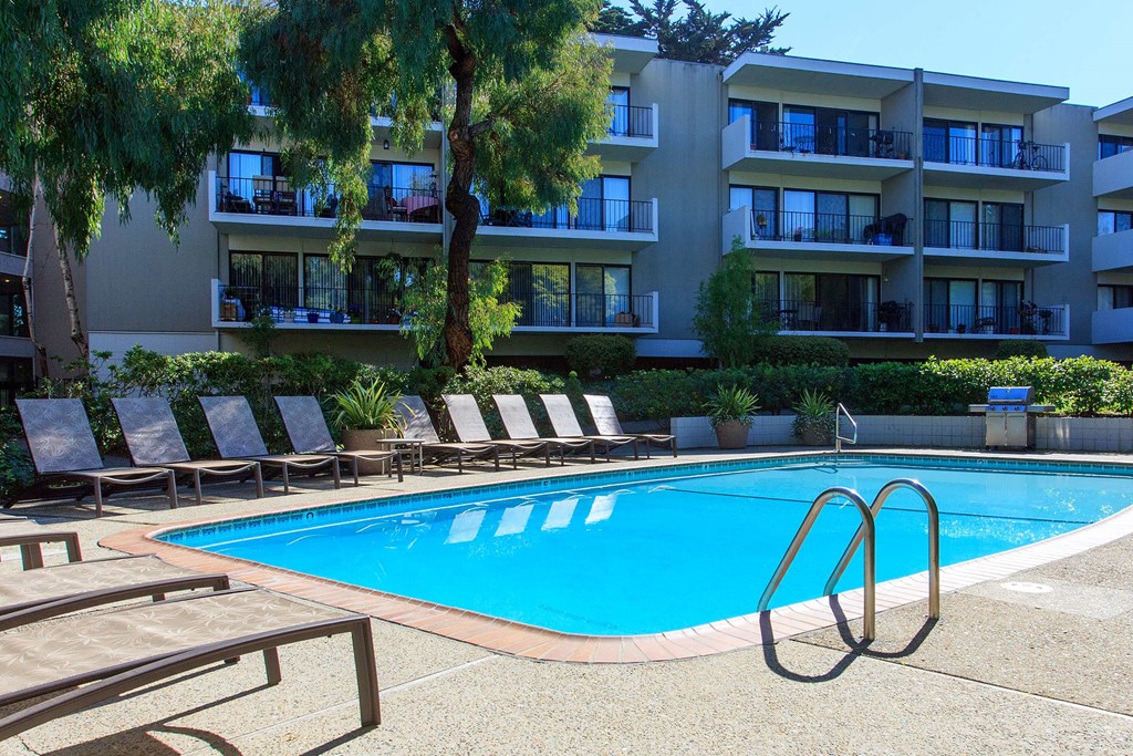 a large swimming pool in front of an apartment building