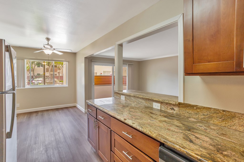 A kitchen with wooden cabinets and a marble countertop.