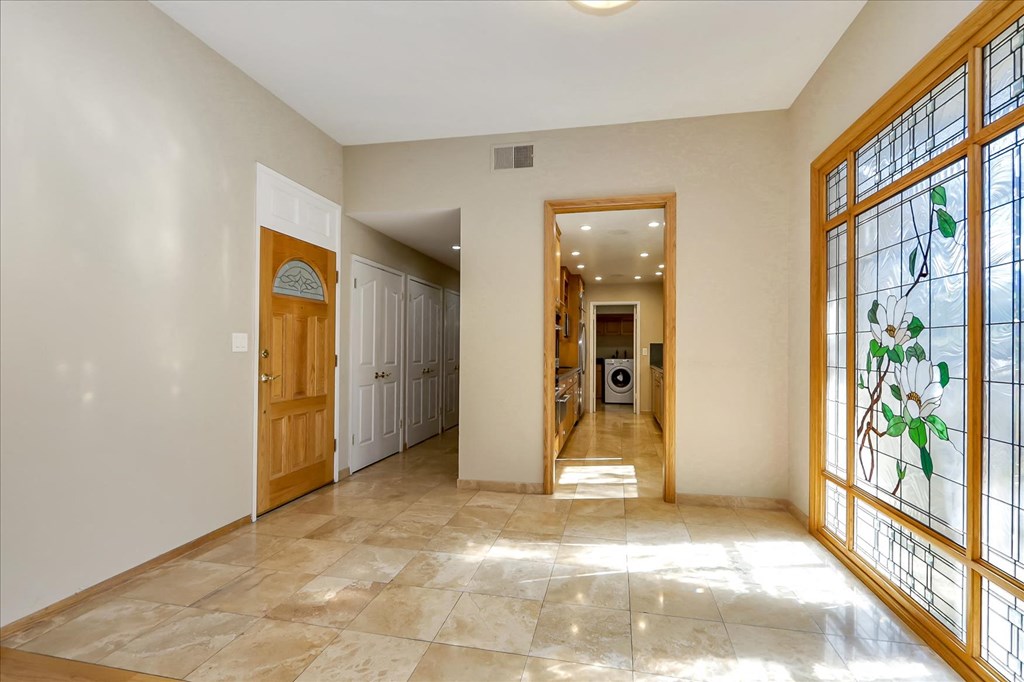 a large hallway with windows and a door and a tile floor