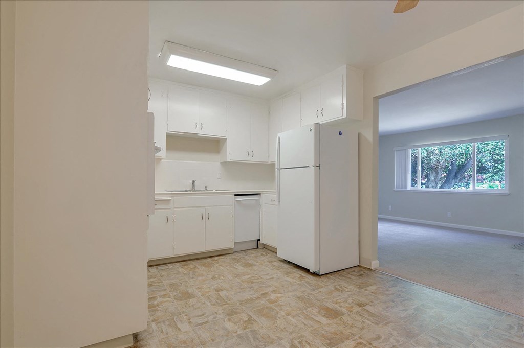 A kitchen with white appliances and cabinets.