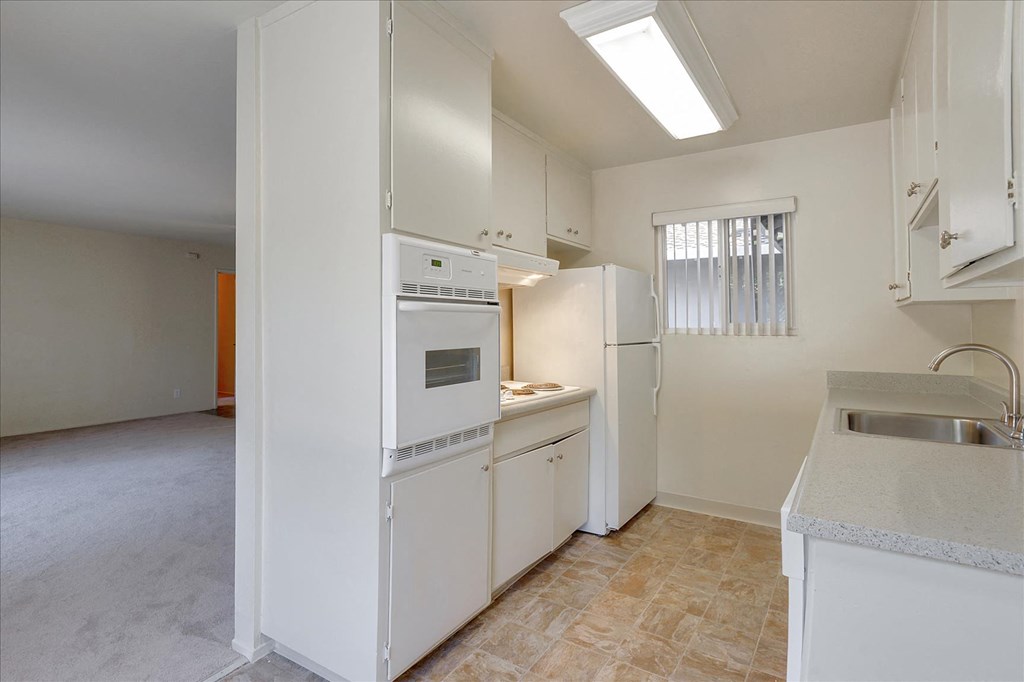 A kitchen with white appliances and cabinets.