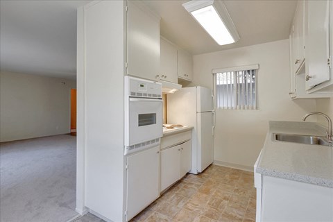 a kitchen with white appliances and a sink and a refrigerator