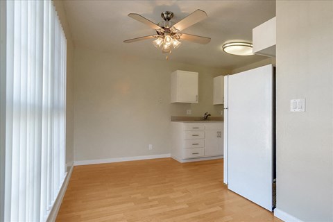 a kitchen with a white refrigerator and a ceiling fan