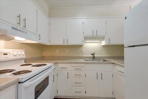 a kitchen with white appliances and white cabinets