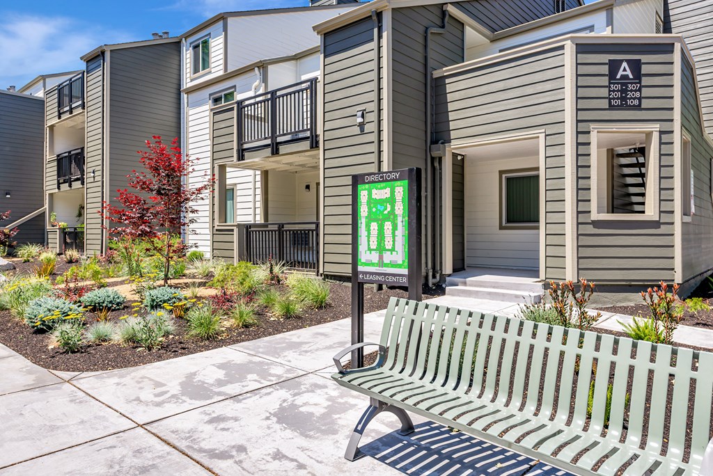 A bench is in front of a building with a green sign that says "A".