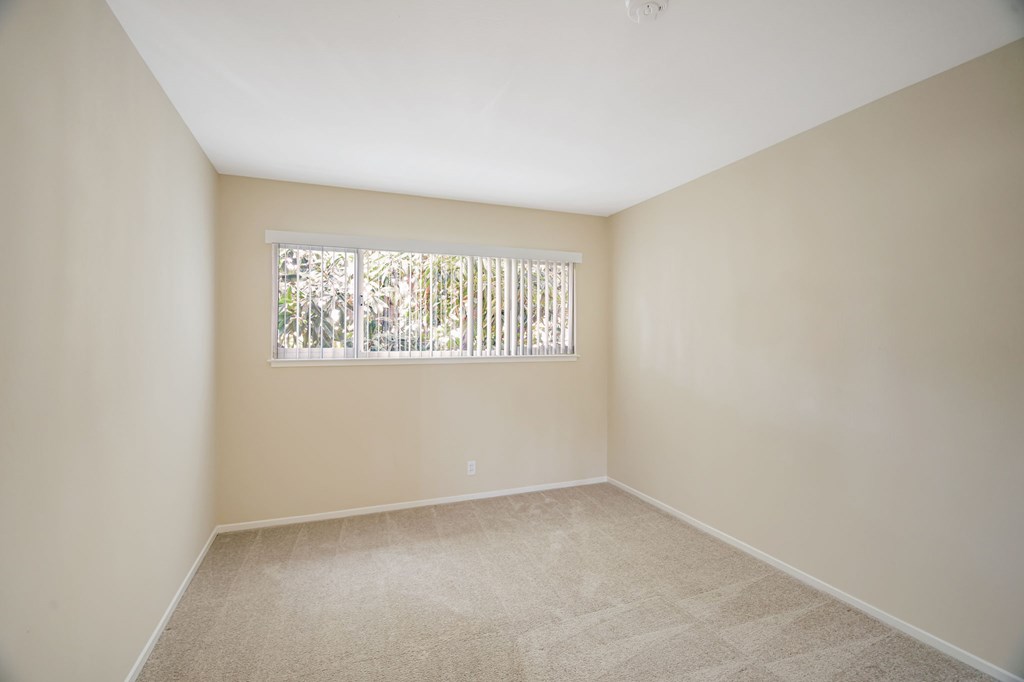 A room with a window covered by a white blind.