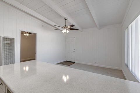 A spacious room with a ceiling fan and a large table.