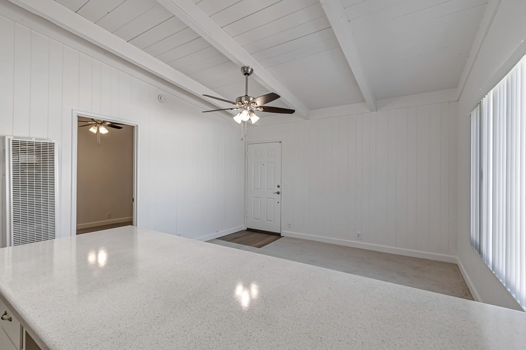 A spacious room with a ceiling fan and a large table.