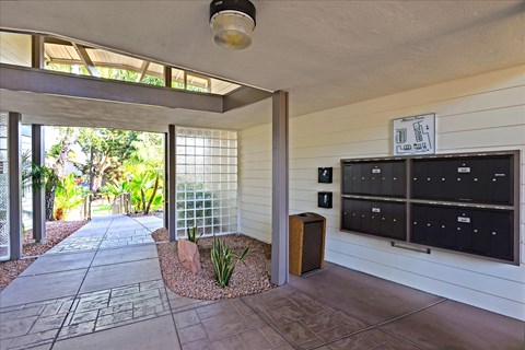 A modern house with a white exterior and a stone pathway leading to the entrance.