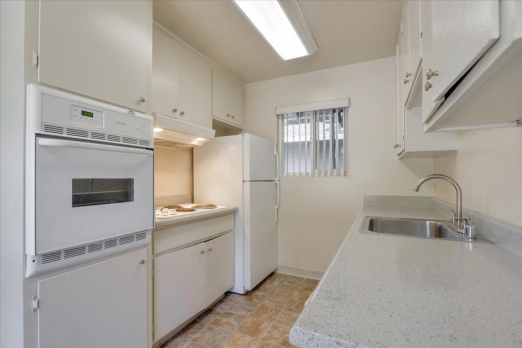 A kitchen with white appliances and cabinets.