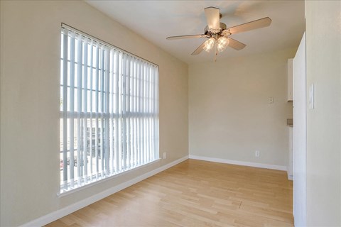 a living room with a large window and a ceiling fan