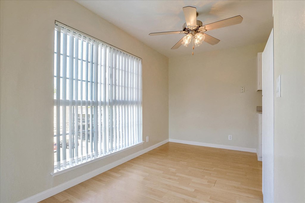 a living room with a large window and a ceiling fan