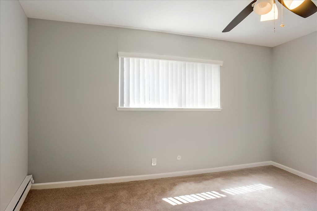 A room with a window and a ceiling fan.