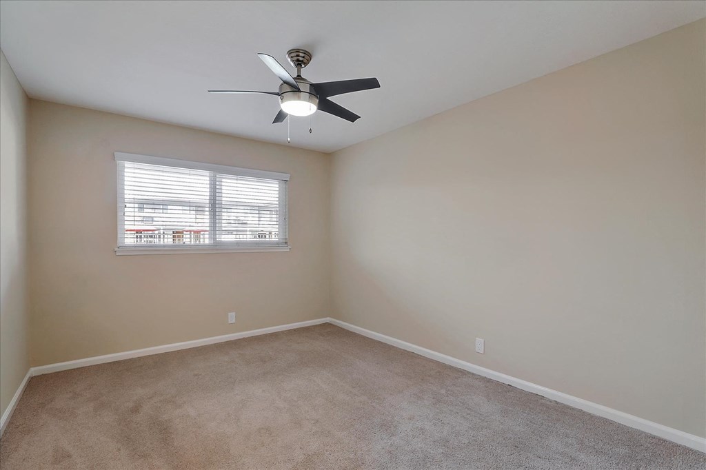a bedroom with a ceiling fan and a window